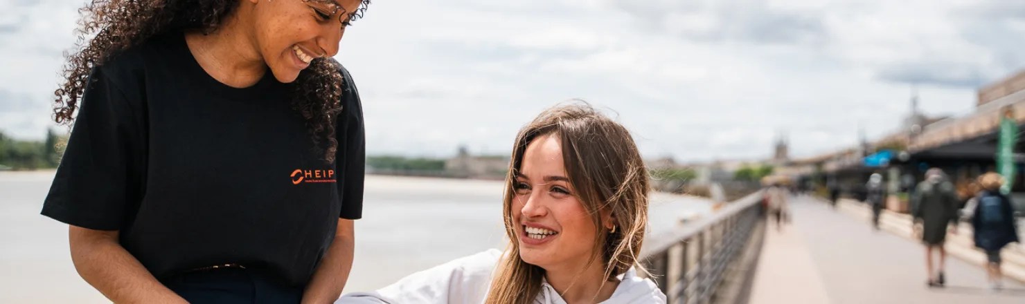 Duo d’étudiantes en heip qui sourient en extérieur